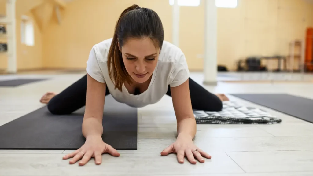 Woman practicing Kriya Yoga Breathing Techniques in Mandukasana (Frog Pose) for inner peace and relaxation.