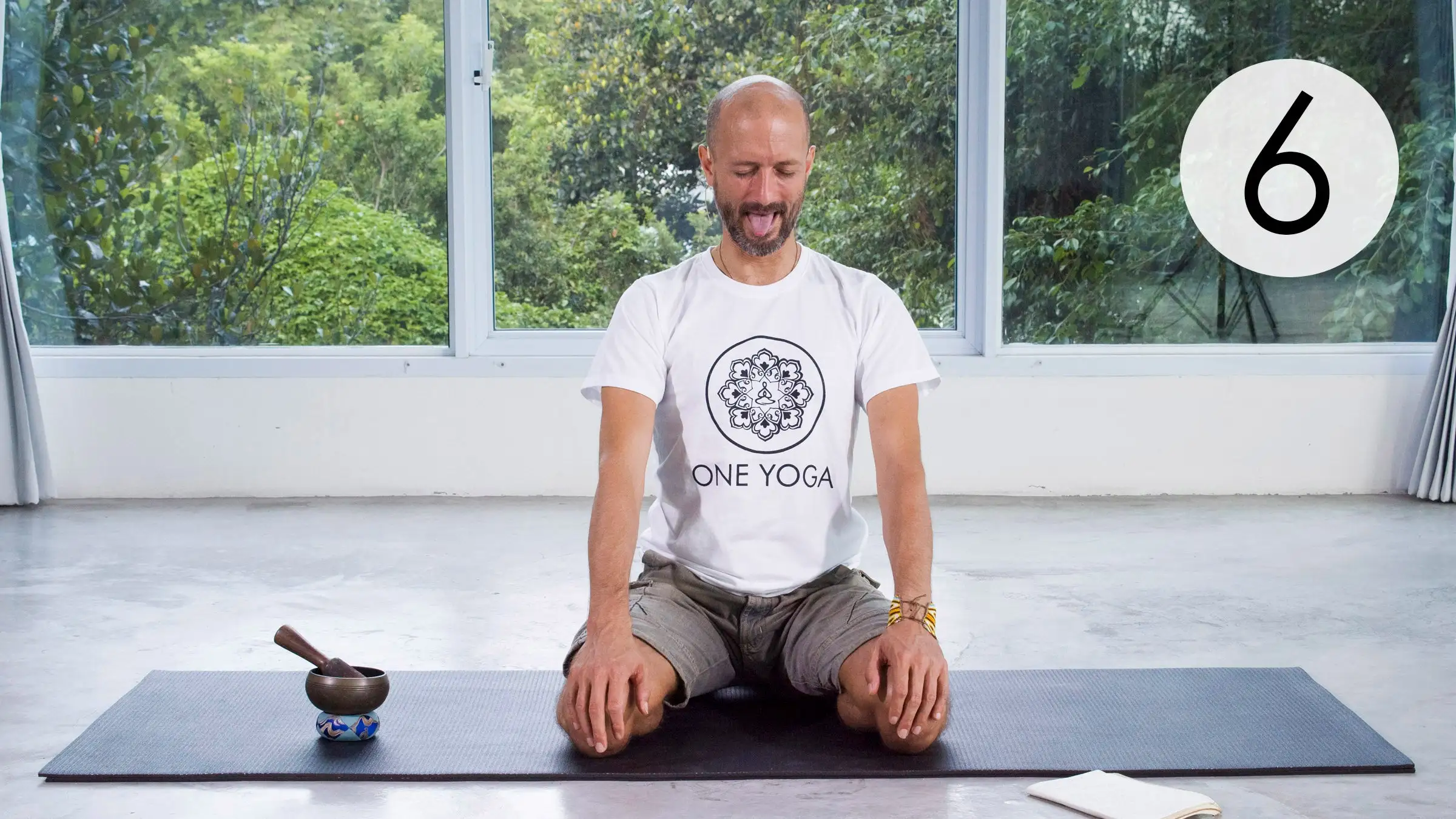 Young man sitting cross-legged on a beige couch, eyes closed, hands resting on her knees in Jnana Mudra, practicing Kriya Yoga Breathing Techniques. The text 'Kriya Yoga Breathing Techniques' and 'Breathe for Inner Peace' are displayed on the left side.