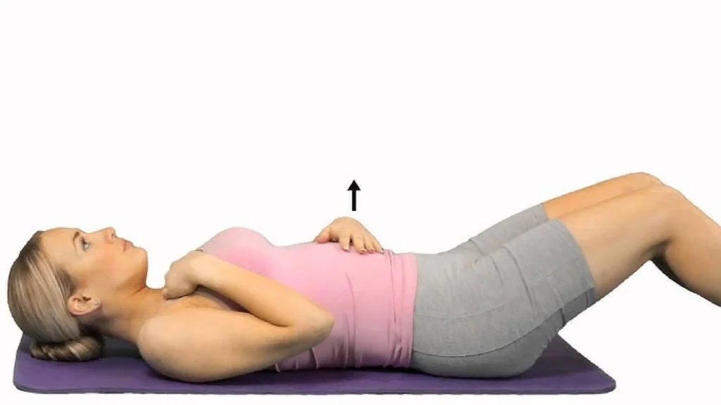 Woman practicing somatic Pilates breathing exercise on a yoga mat