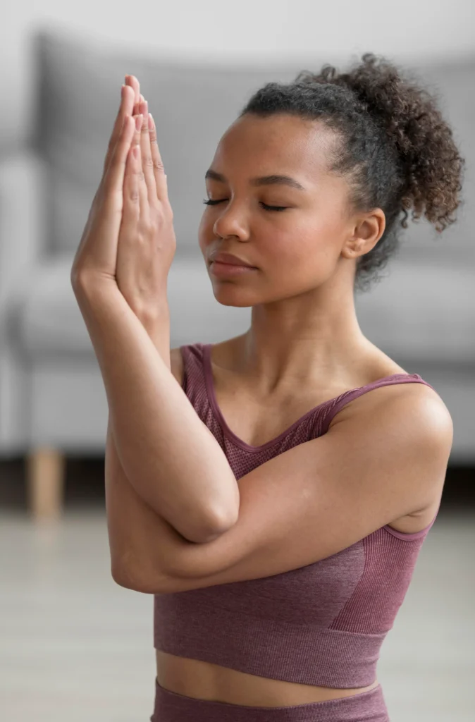 Beginner practicing a gentle yoga pose representing Asana, the third limb of the eight limbs of yoga philosophy, showing mind–body connection.